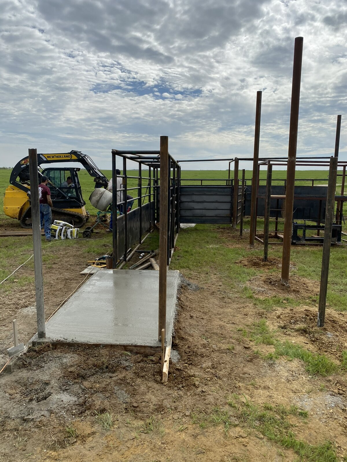 Cattle working chute and alley being set on a fresh concrete pad at a private ranch near Nocona